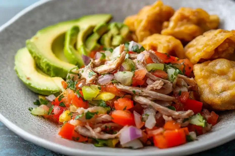 Caribbean smoked herring buljol with tomatoes, onions, bell peppers, avocado, and fried dumplings.